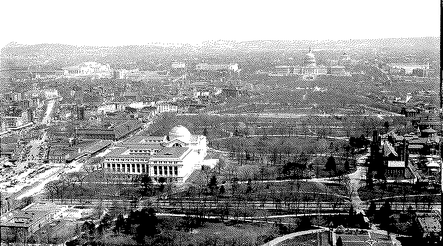 A view from the Washington Monument over the city, with a domed museum building in the middle distance and streets and trees beyond.