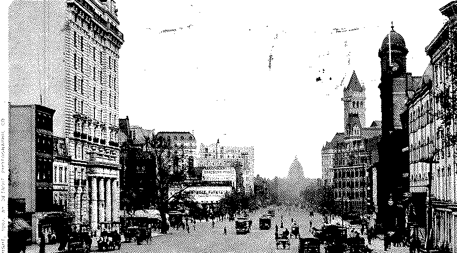 Pennsylvania Avenue in Washington looking towards the Capitol dome in the distance, with early motor cars and horse traffic between tall buildings.