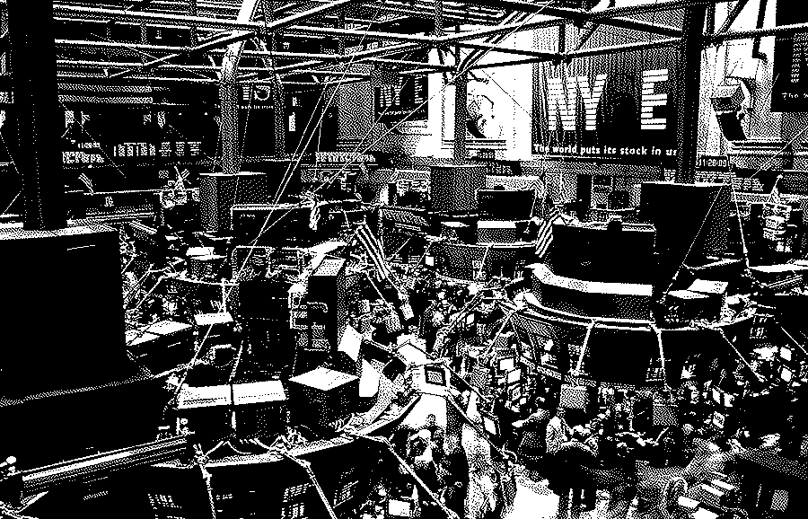 High view of the New York Stock Exchange trading floor with its steel trusses, hanging screens, trading posts, flags and a crowd of traders below, and an NYSE banner on the far wall.