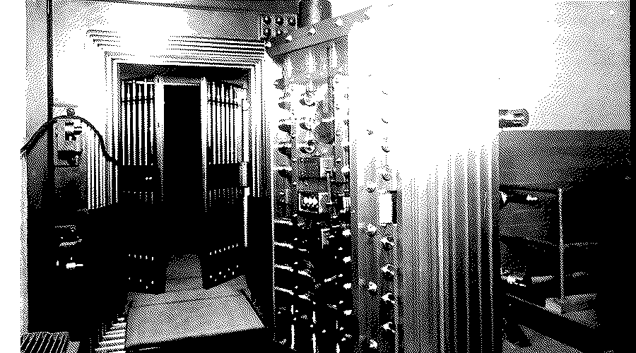 The open twelve-ton steel door of a vault at the Bureau of Engraving and Printing, with rows of bolts along its edge and the vault beyond.