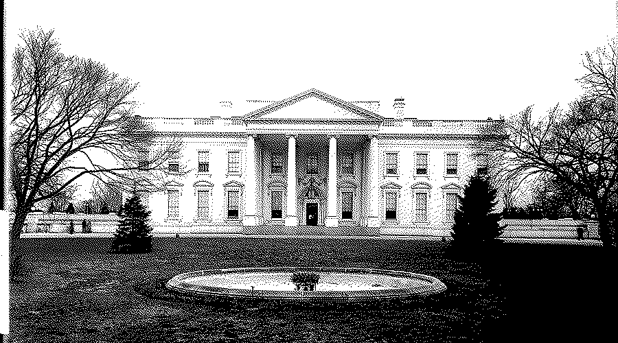 North front of the White House seen across a lawn with a round fountain basin and bare trees at both sides.